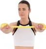 A woman is holding a yellow Pilates training band. Produktbild-Vorschau