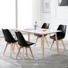 A dining table with four black chairs around it, set in a well-lit room. Produktbild-Vorschau