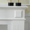 A close-up view of a white fireplace surround with decorative molding and a square inset detail. Anteprima dell’immagine prodotto