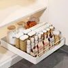 A white pull-out drawer organizer filled with various pantry items like jars of flour, grains, spices, and boxes of chocolate chunks, neatly arranged on a shelf. Produktbild-Vorschau