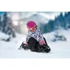 A young girl is sledding down a snowy hill on a black and pink sled. Anteprima dell’immagine prodotto