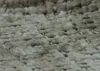 A close-up, textured view of green chenille fabric, likely from a chair or sofa. Voir les images du produit