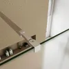 A close-up view of a shower enclosure support arm and a shelf with toiletries. Produktbild-Vorschau