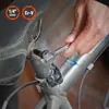 A person's hand is using a small ratchet tool to tighten a bolt on a bicycle seat post. Náhled obrázku produktu