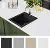 A black granite sink is shown on a white countertop with green cabinets below. Several color swatches are displayed at the bottom of the image. Náhled obrázku produktu