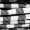 A close-up view of a folded picnic blanket with a gray and white checkered pattern. Produktbild-Vorschau