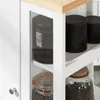 A close-up view of a white kitchen cart with a wooden top, showing storage containers and jars on shelves. Produktbild-Vorschau