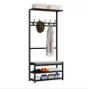 A black metal coat rack with a bench and shoe shelves, displaying a hat, a coat, and shoes. Produktbild-Vorschau