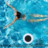 A person swimming in a pool with a solar-powered pool cleaner floating nearby. Náhled obrázku produktu