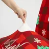 A hand is stretching a Christmas-themed chair cover. Náhled obrázku produktu