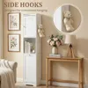 A tall, narrow white cabinet with doors and shelves, placed in a room setting with decorative items. Voir les images du produit