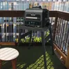 A Ninja Woodfire Pro XL electric grill is set up on a balcony with a city view in the background. Voir les images du produit