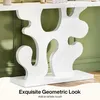 A close-up of a white console table with an artistic geometric base, set against a green wall. Anteprima dell’immagine prodotto