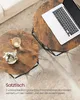 Two round coffee tables with a rustic wood finish and black metal legs are shown in a living room setting, with a laptop on one table and a small plant and cup on the other. Podgląd zdjęcia produktu