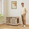 A man stands next to a wooden dog crate in a room. Náhled obrázku produktu