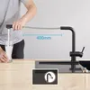 A person is filling a glass with water from a black kitchen faucet with a pull-out spray. Produktbild-Vorschau