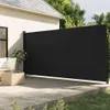 A black retractable side awning is extended on a wooden deck next to a house. Produktbild-Vorschau