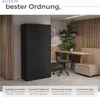 A modern office or workshop space with a black metal cabinet, a wooden desk, and seating. Produktbild-Vorschau