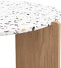 Close-up of a terrazzo table top and wooden leg. Voir les images du produit