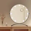 A round makeup mirror with lights on a wooden dresser. Podgląd zdjęcia produktu