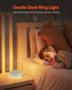 A child sleeping in bed next to a bedside table with a white noise machine and a gentle glow ring light. Produktbild-Vorschau