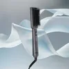 A gray hair straightening brush is shown against a background of flowing white and light blue fabric. Produktbild-Vorschau