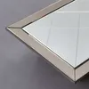 A close-up shot of the corner of a diamond-shaped mirror with a silver frame. Produktbild-Vorschau