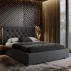 A bedroom scene featuring a dark gray upholstered bed with a tufted headboard, set against a textured wooden wall and brown curtains. Náhled obrázku produktu