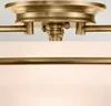 Close-up view of a brass and white ceiling light fixture. Produktbild-Vorschau