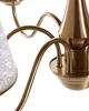 A close-up view of a brass-colored chandelier with a white glass shade. Náhled obrázku produktu