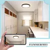 A hand holding a smartphone displaying a ceiling light, with a laundry room in the background. Náhľad obrázku produktu