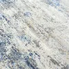A close-up, angled view of a textured rug with an abstract pattern. Podgląd zdjęcia produktu