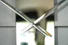 Close-up of a modern silver wall clock with metallic hands. Náhled obrázku produktu