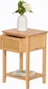 A wooden nightstand with a drawer and a shelf, topped with a white vase holding white flowers. Podgląd zdjęcia produktu