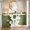 A white console table with a decorative base is placed in a hallway with green wainscoting and a textured wall above. An octagonal mirror with a gold frame hangs on the wall above the table, which is adorned with a lamp, decorative sculptures, and a vase w Anteprima dell’immagine prodotto