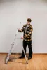A man is standing next to a ladder. Náhľad obrázku produktu