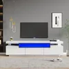 A modern living room with a white TV stand featuring blue LED lighting, a television, and decorative items. Produktbild-Vorschau