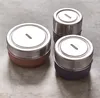 Three cylindrical containers with metallic lids and textured bases are arranged on a gray surface. Podgląd zdjęcia produktu