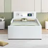 A white bed with a headboard featuring storage compartments and a built-in night light. Produktbild-Vorschau