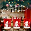 A festive Christmas-themed kitchen scene with Santa Claus chair covers. Produktbild-Vorschau