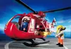 A red rescue helicopter with two figures, one inside and one standing next to it, on a gray surface with blue sky in the background. Náhľad obrázku produktu