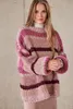 A woman wearing a striped knitted sweater. Produktbild-Vorschau