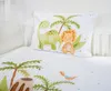 A close-up view of a pillow and duvet cover with a dinosaur and palm tree print, laid out on a white surface. Náhled obrázku produktu