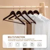Several wooden hangers with clothes hanging on a clothing rack. Produktbild-Vorschau
