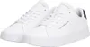 A pair of white Tommy Hilfiger sneakers is shown from a slightly elevated side angle against a white background. Voir les images du produit