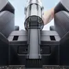 A hand is using a portable car vacuum cleaner to clean the center console of a car. Produktbild-Vorschau