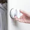A hand is shown attaching a white suction cup handle to a white surface, possibly a door or cabinet. Produktbild-Vorschau