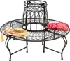 A round metal garden bench with a decorative center piece, a straw hat with colorful ribbons, and a patterned pillow on it, set against a white background. Náhled obrázku produktu