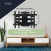 A wall-mounted TV bracket is shown mounted on a wall above a TV stand, with dimensions and VESA compatibility information overlaid. Produktbild-Vorschau