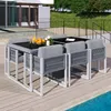 An outdoor dining set with chairs and a table is placed on a wooden deck next to a swimming pool. Produktbild-Vorschau